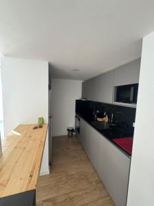 a kitchen with black and white cabinets and a wooden counter top at Apartamento Piriapolis in Piriápolis +8 photos
