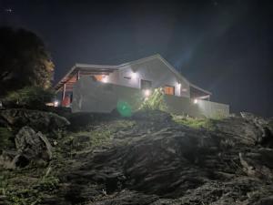 a house on a hill at night with lights at Xaraba in Villa Parque Siquiman