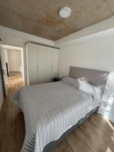 a bedroom with a bed with a striped blanket at Apartamento Piriapolis in Piriápolis