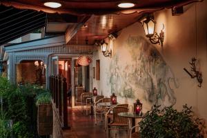a restaurant with tables and chairs and a painting on the wall at Casa da Montanha in Gramado