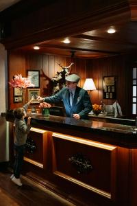 a man standing at a counter with a little boy at Casa da Montanha in Gramado