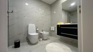 a white bathroom with a toilet and a sink at FERREIRA'S HOUSE Guimarães in Guimarães +110 photos