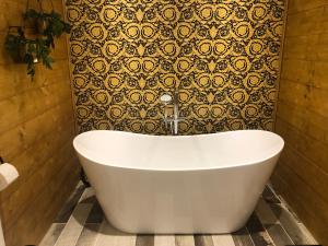 a white bath tub in a bathroom with a wall at Roundstone View in Bewdley +19 photos