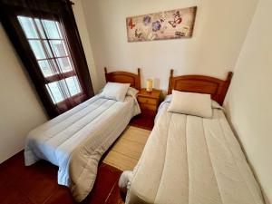 two beds in a small room with a window at Lupita's House in Punta Mujeres +20 photos