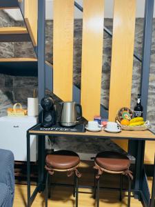 a table with two stools with a pot on it at Cozy House in Funchal