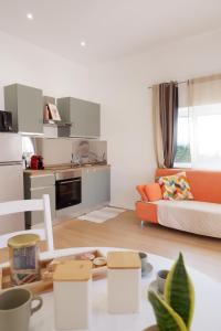 a living room with an orange couch and a kitchen at La Casa del Borgo in Rieti