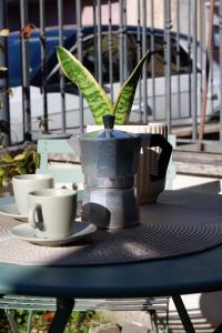 a table with a potted plant and cups on it at La Casa del Borgo in Rieti