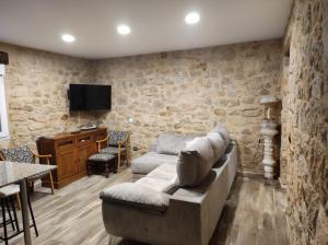 a living room with a couch and a tv at Casa Rural La Atalaya in Montarrón
