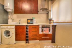 a small kitchen with a stove and a microwave at Triana Home centro ciudad in Murcia