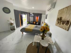a bedroom with a bed and a vase of flowers on a table at Royal Terrace Apto. II (Princess) in San Felipe de Puerto Plata