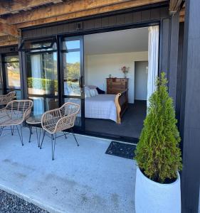a bedroom with a bed and chairs on a patio at Moana BnB, Picton in Picton +1 photo