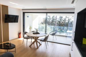 a living room with a table and chairs and a large window at The L Smart Suite - Premium & Minimal in Ierapetra +20 photos