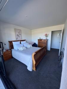 a bedroom with a large bed and a dresser at Moana BnB, Picton in Picton