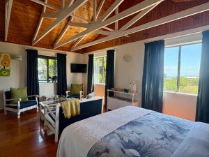 a bedroom with a bed and a room with windows at Sunny studio in the sky in Brenton-on-Sea