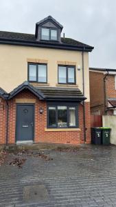 a brick house with a blue door and windows at Mill House in West Bromwich
