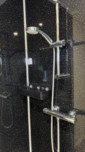 a shower in a bathroom with a black wall at Mill House in West Bromwich +24 photos