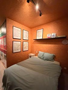 a bedroom with a bed and some pictures on the wall at Fiets Kot in Keerselaar