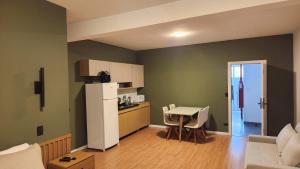 a kitchen with a white refrigerator and a table at Studio Cotia Próximo ao Thermas da Mata, Animalia Park e CT São Paulo in Cotia