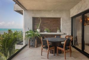 a dining room with a table and chairs and the ocean at Luxury 3BR Apartmen Tankah Beach plus Rooftop in Tulum