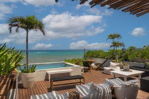 a patio with a swimming pool and the ocean at Luxury 3BR Apartmen Tankah Beach plus Rooftop in Tulum