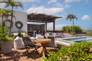 a patio with a table and chairs next to a swimming pool at Luxury 3BR Apartmen Tankah Beach plus Rooftop in Tulum