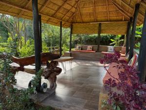 a patio with a pavilion with a table and benches at StoneWoodGrey in Harare