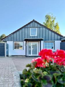 a house with red flowers in front of it at Wellnesshaus - Whirlpool - Sauna - Relax in Herten