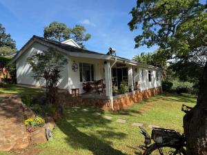 a small white house with a man on the roof at StoneWoodGrey in Harare +30 photos