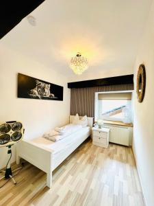 a bedroom with a white bed and a chandelier at Apartment direkt an der Waldnaab in Neustadt an der Waldnaab +57 photos