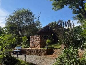 a brick building with a bench in a garden at StoneWoodGrey in Harare