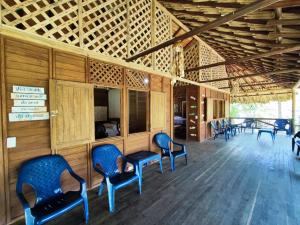 a room with chairs and wooden walls and wooden ceiling at Cabaña con Deck Frente al Mar para 8 personas in Moñitos