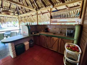 a kitchen with a sink and a counter with a basket of fruit at Cabaña con Deck Frente al Mar para 8 personas in Moñitos
