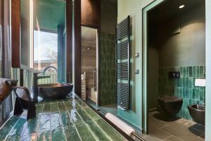 a bathroom with two sinks and two tubs at Floris Green Suites by Parc Hotel Florian in Siusi +50 photos