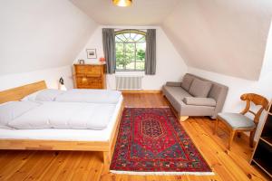 a bedroom with a bed and a chair and a rug at Feriengut Welzin in Welzin +64 photos