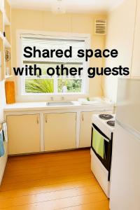 a kitchen with the words shared space with other guests at Boxed Bliss on Fox in Hamilton
