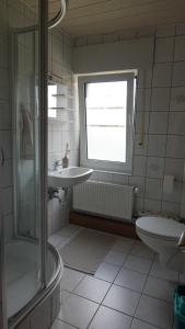 a bathroom with a sink and a shower and a toilet at FeWo Kalletal in Kalletal +8 photos