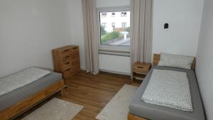 a small room with two beds and a window at FeWo Kalletal in Kalletal