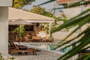 a pool with a table and an umbrella and chairs at Greco Mare 99 in Kavos