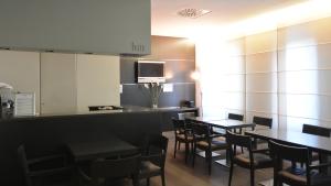 a restaurant with tables and chairs and a counter at Hotel Corallo in Milan
