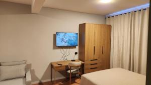 a bedroom with a desk and a bed and a cabinet at Studio Cotia Próximo ao Thermas da Mata, Animalia Park e CT São Paulo in Cotia