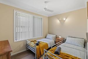 a bedroom with two beds and a window at Lemon Tree Getaway Inn in Lemon Tree Passage