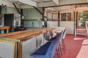 a bar in a restaurant with blue chairs at Lemon Tree Getaway Inn in Lemon Tree Passage +13 photos