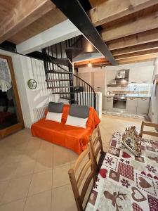a bedroom with an orange bed and a kitchen at BORMIO Alpine Suite in Valdidentro