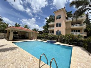 a house with a swimming pool in front of a house at Ocean Vibes near Rincón Beachfront Access Condo in Matias