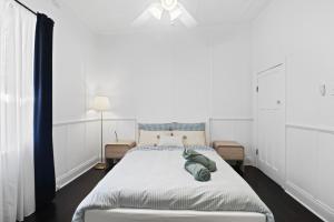a bedroom with a bed with a stuffed animal on it at Mildas Cottage Hunter Valley in Cessnock