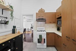 a kitchen with a white stove and wooden cabinets at Mildas Cottage Hunter Valley in Cessnock