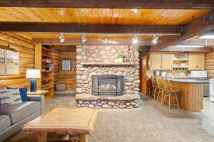 a living room with a stone fireplace in a log cabin at The Hailey Cabin in Island Park