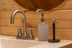 a sink with a soap dispenser and a soap dispenser at The Hailey Cabin in Island Park +28 photos