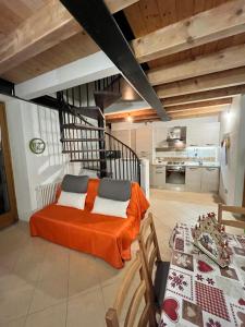 a bedroom with an orange bed and a kitchen at BORMIO Alpine Suite in Valdidentro