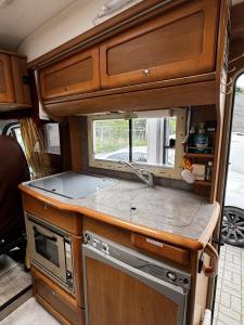 an rv kitchen with wooden cabinets and a sink at Rover Rentals in Inverness